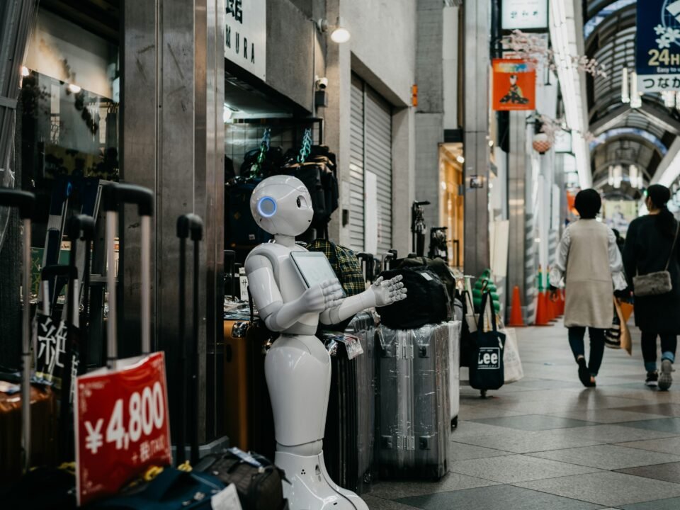 A bot is standing outside a shop holding a board.